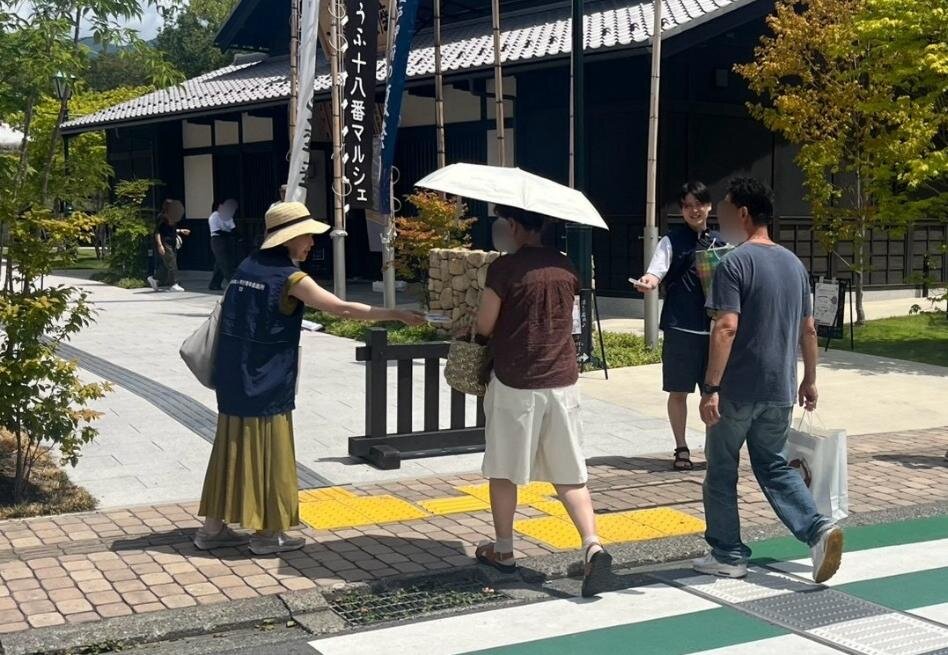 来場者へ献血啓発ティッシュを手渡す会員
